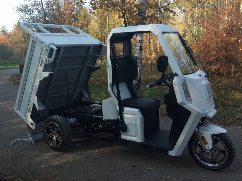 Electric dumper carrying sand and tools for grave preparation.